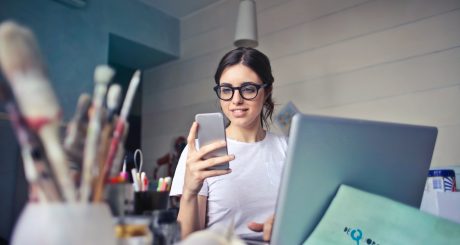 woman in white shirt using smartphone