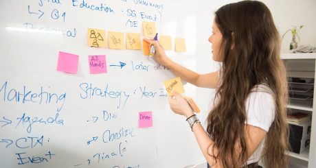 woman in blue denim jacket holding yellow sticky notes