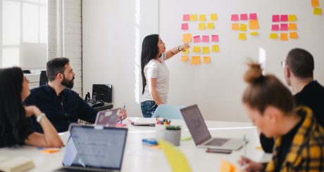 woman placing sticky notes on wall